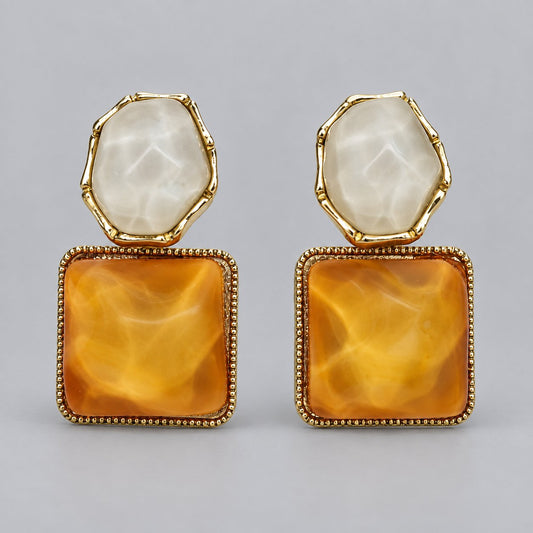 Front view of the gold-tone earrings with amber marbled square and pale stone stud top