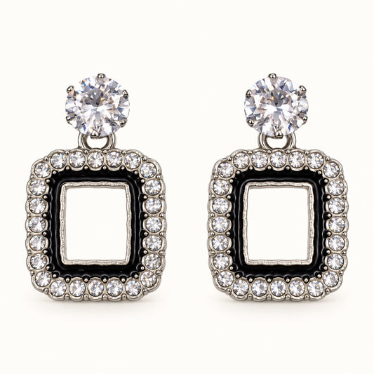 Front view of the silver-tone Noir square halo drop earrings with black enamel and crystal edge