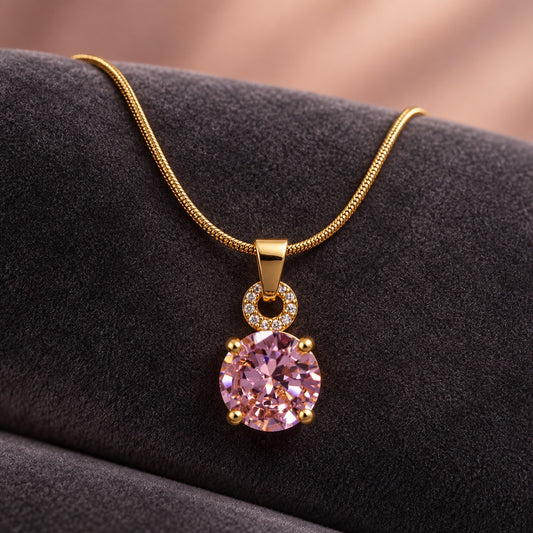 Blush Solitaire Pendant Necklace gold-tone snake chain with blush pink solitaire stone on grey velvet