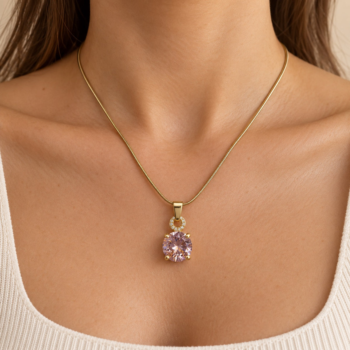 Model wearing Blush Solitaire Pendant Necklace gold-tone snake chain