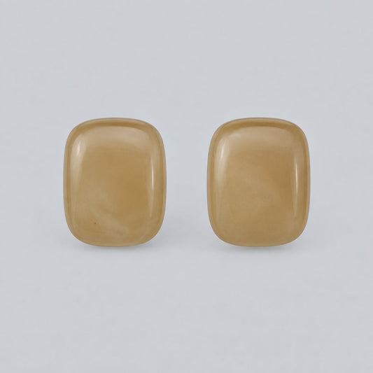 Front view of champagne cushion cabochon stud earrings with gold-tone rim