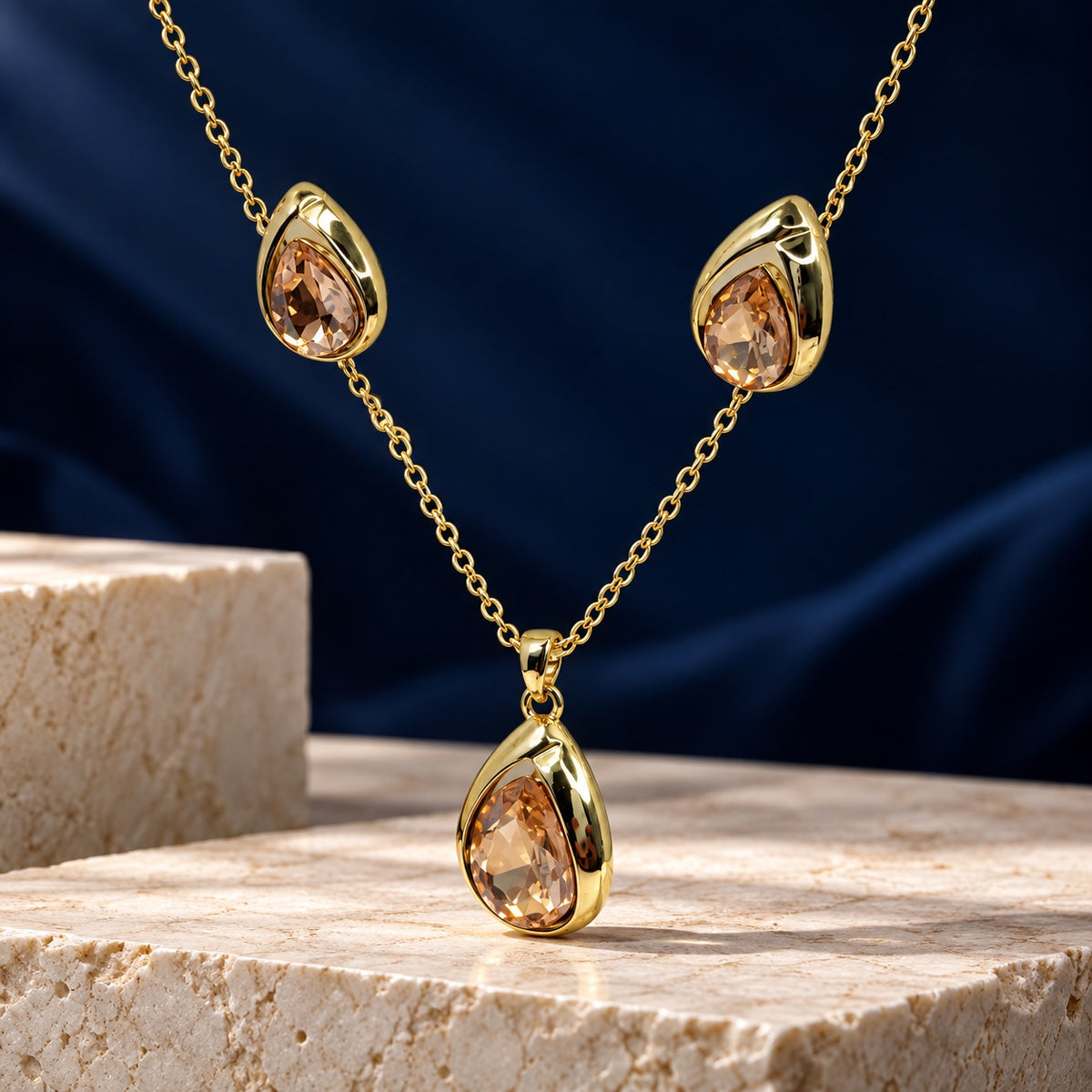 Champagne Teardrop Necklace Set gold-tone pendant necklace and matching earrings with champagne stones on a stone block