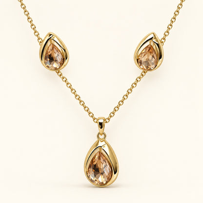 Front view of champagne teardrop necklace and matching earrings in gold-tone settings