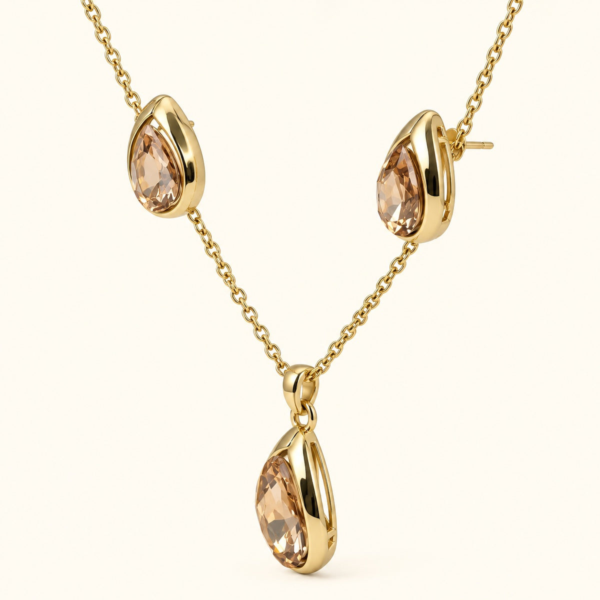 Side view of champagne teardrop necklace set showing the curved gold-tone bezels