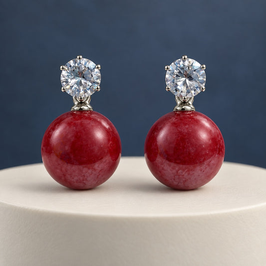 Cherry Red Lustre Orb Drops silver-tone earrings with sparkling top stones and glossy red orbs on dark slate
