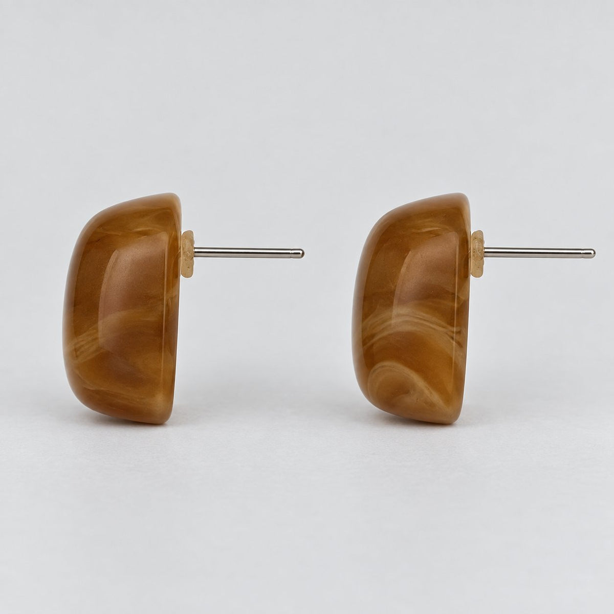 Side view of chestnut cabochon stud earrings showing the domed profile and silver-tone post