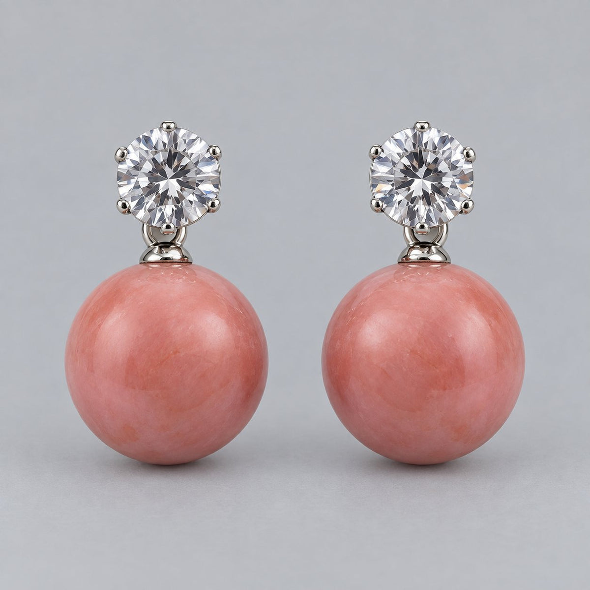 Front view of coral pink orb drop earrings with sparkling round top stones