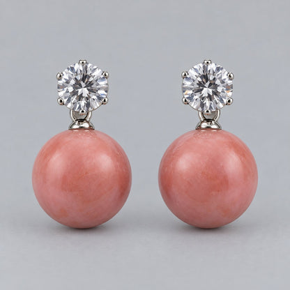 Front view of coral pink orb drop earrings with sparkling round top stones
