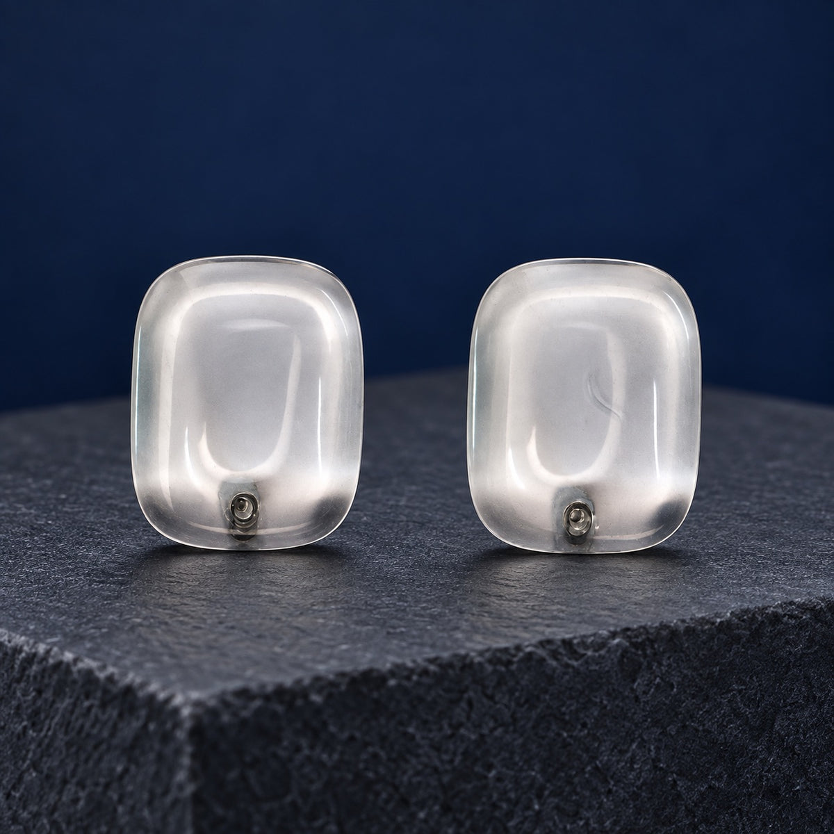 Crystal Clear Cabochon Studs transparent cushion stud earrings with silver-tone posts on a marble block