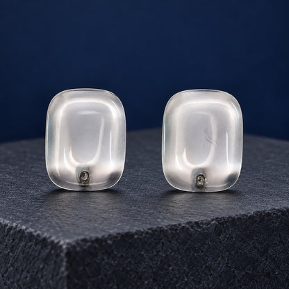 Crystal Clear Cabochon Studs transparent cushion stud earrings with silver-tone posts on a marble block