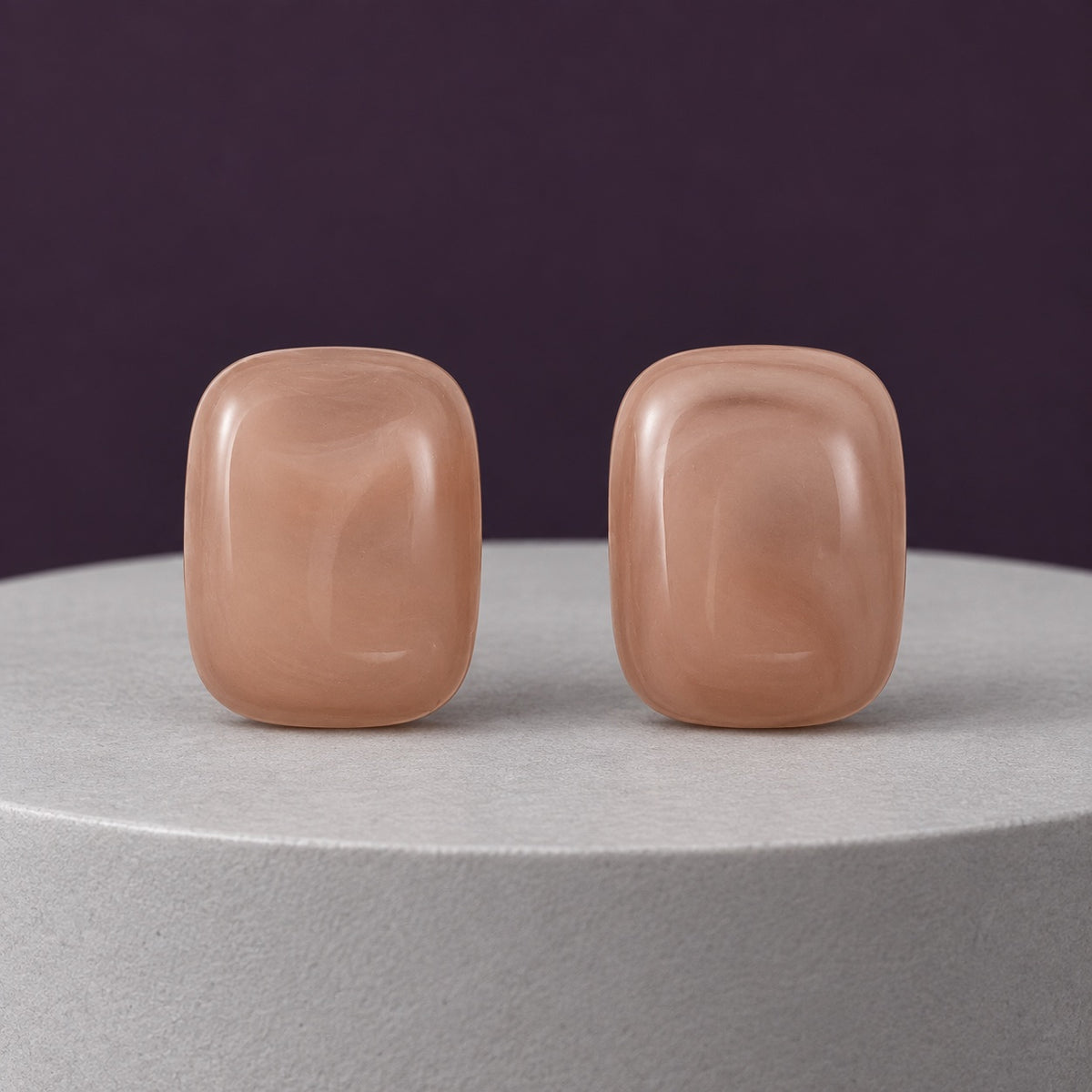Dusty Rose Cabochon Studs muted pink cushion stud earrings on a travertine block