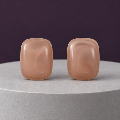 Dusty Rose Cabochon Studs muted pink cushion stud earrings on a travertine block