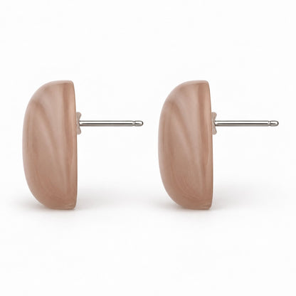 Side view of dusty rose cabochon stud earrings showing the domed profile and silver-tone post