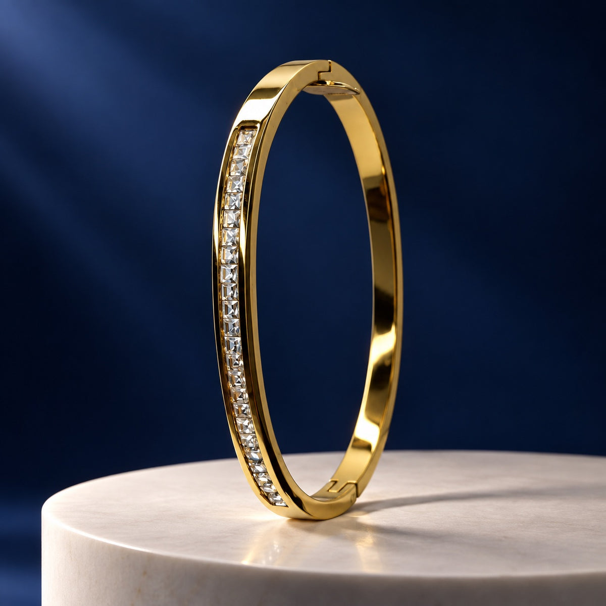 Gilded Channel-Set CZ Bangle gold-tone bangle with square-cut stones on a marble pedestal