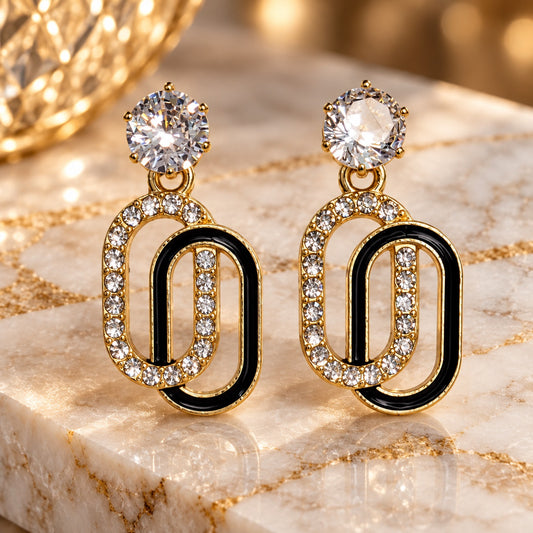 Gilded Noir Oval Link Drops gold-tone oval link drop earrings styled on cream marble