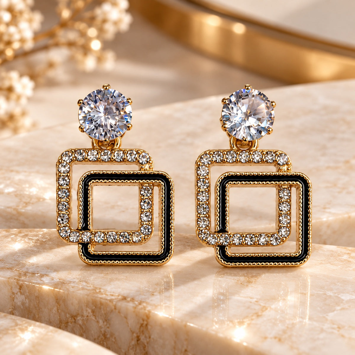 Gilded Noir Square Drops gold-tone square drop earrings styled on cream marble