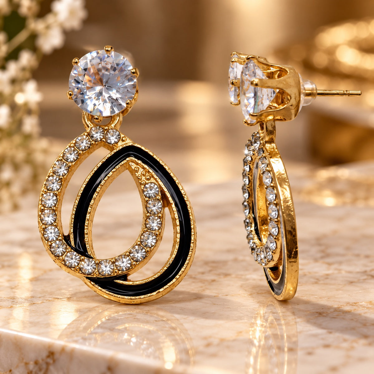 Gilded Noir Teardrop Earrings gold-tone teardrop earrings styled on cream marble