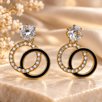 Gilded Noir Twin Orbit Drops gold-tone twin orbit drop earrings styled on cream marble