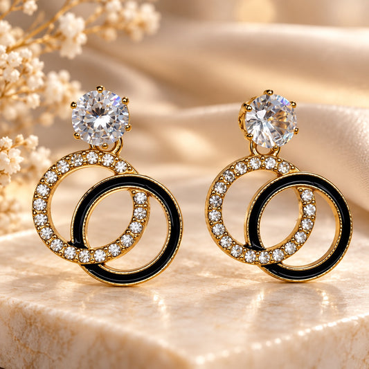 Gilded Noir Twin Orbit Drops gold-tone twin orbit drop earrings styled on cream marble