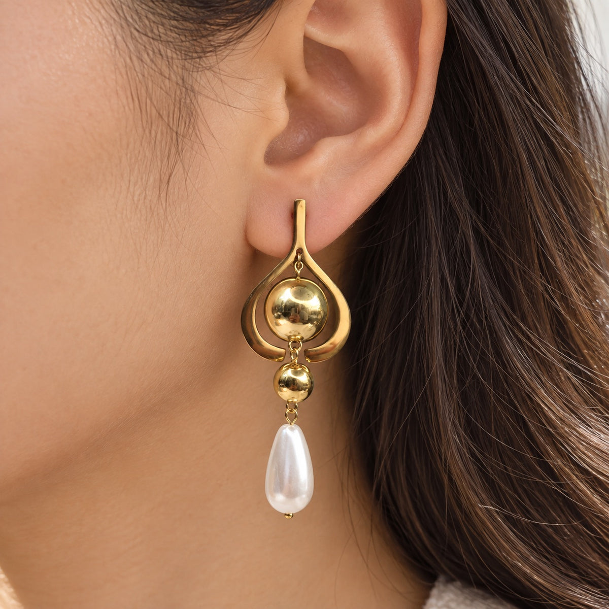 Gilded Pearl Teardrop Chandeliers gold-tone pearl teardrop chandelier earrings worn on model