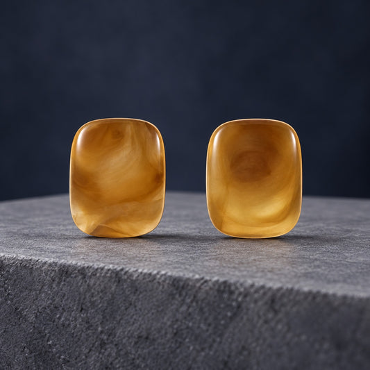 Honey Gold Glaze Cabochon Studs with translucent honey gold cushion stones on a travertine ledge