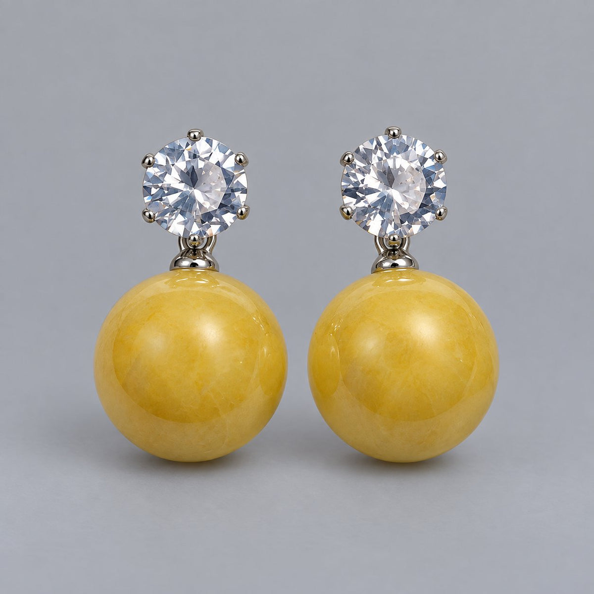 Front view of the silver-tone marigold yellow orb drop earrings