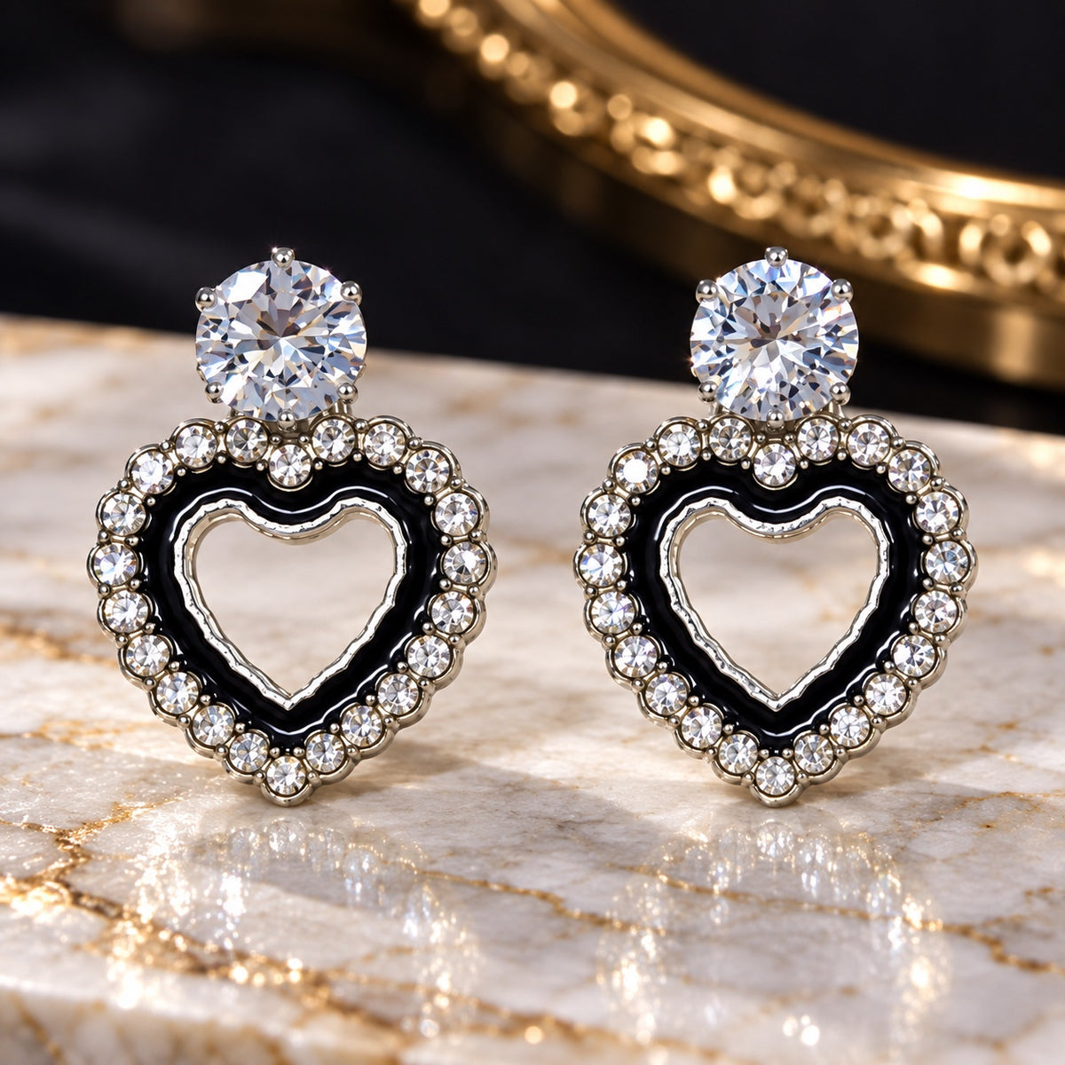 Noir Heart Halo Drops with sparkling stone tops and black enamel heart shaped halos on a marble surface