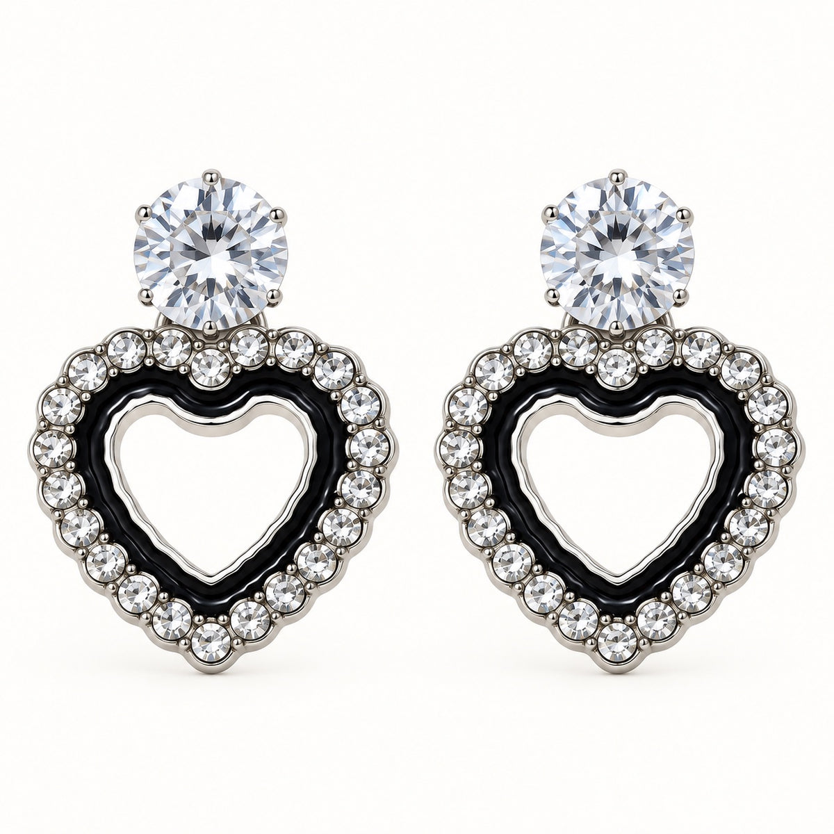 Front view of the silver-tone Noir heart halo drop earrings with black enamel and crystal edge