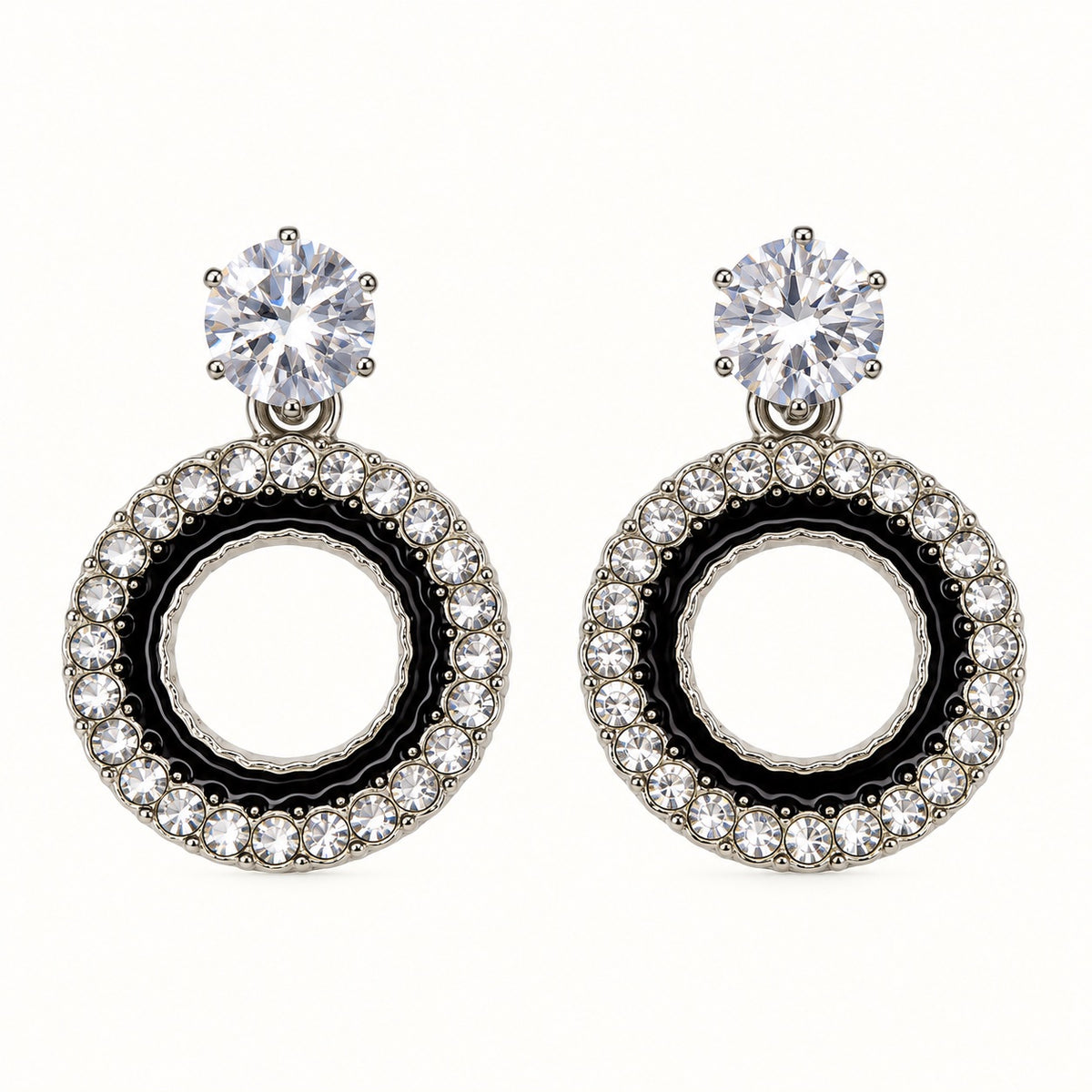 Front view of the silver-tone Noir orbit halo drop earrings with black enamel and crystal edge