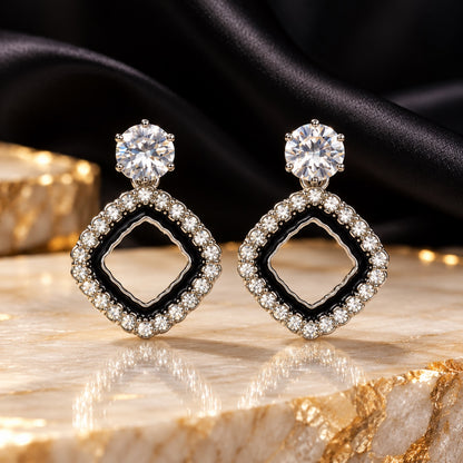 Noir Rhombus Halo Drops with sparkling stone tops and black enamel rhombus shaped halos on a marble surface