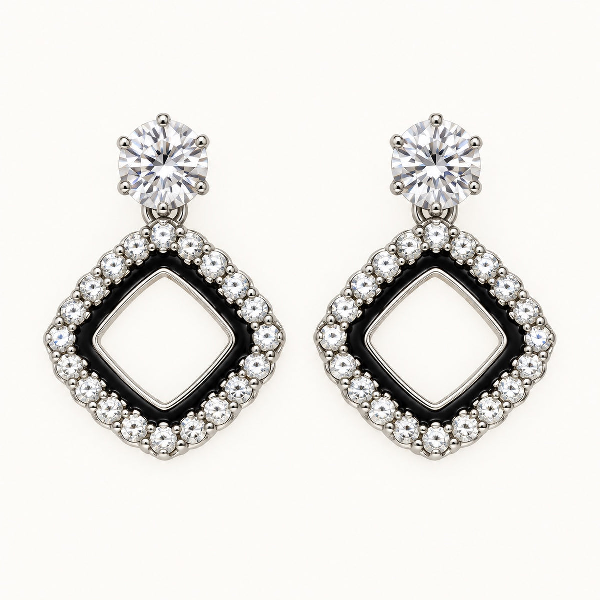 Front view of the silver-tone Noir rhombus halo drop earrings with black enamel and crystal edge