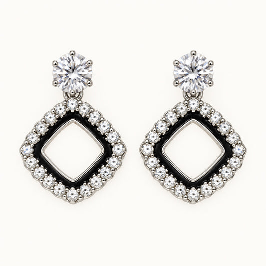 Front view of the silver-tone Noir rhombus halo drop earrings with black enamel and crystal edge