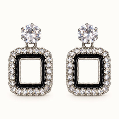Front view of the silver-tone Noir square halo drop earrings with black enamel and crystal edge
