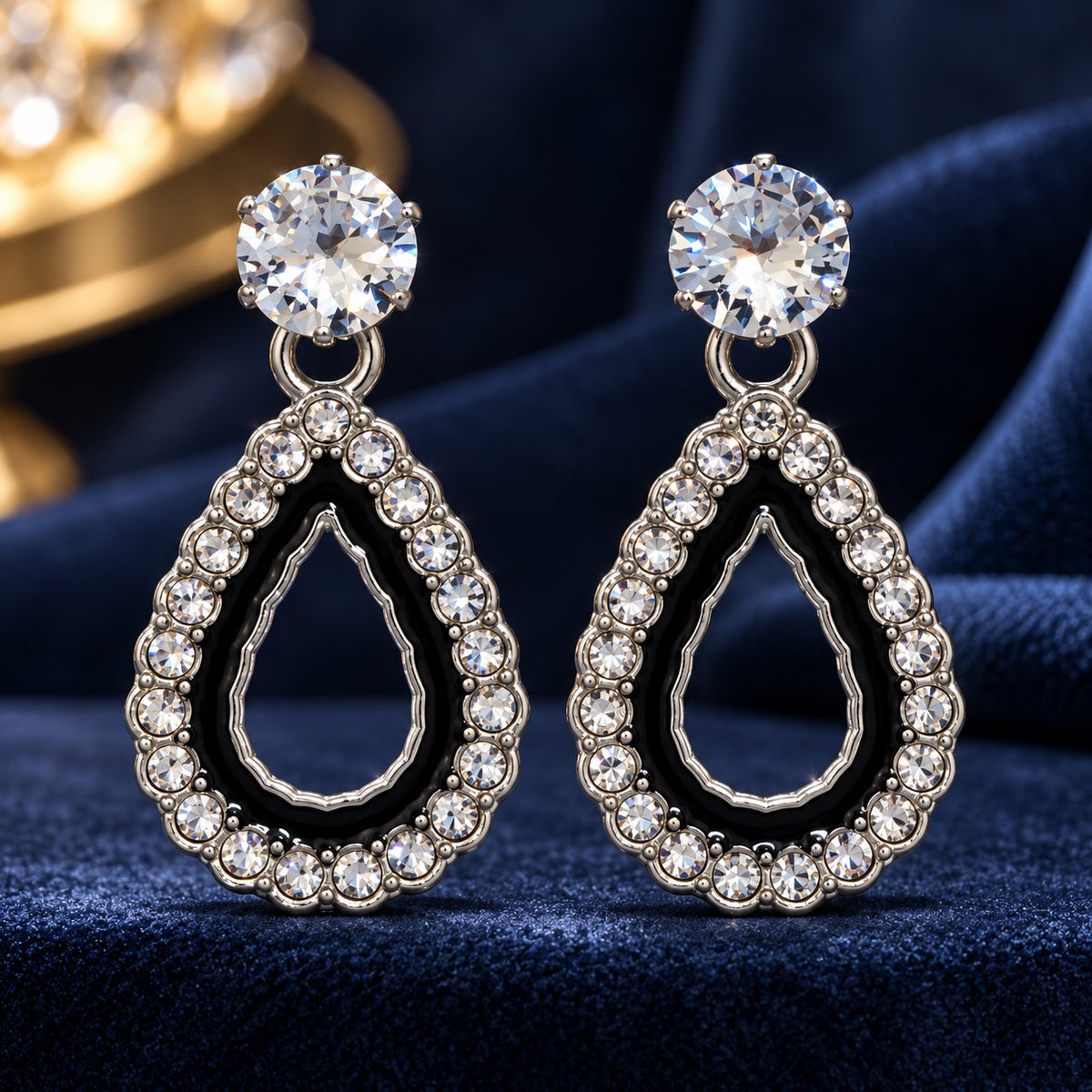 Noir Teardrop Halo Drop Earrings in silver tone with black enamel and crystal halo on navy velvet