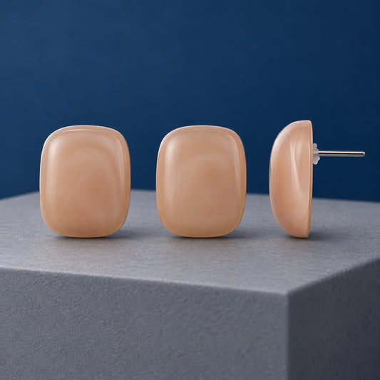 Peach Blush Cabochon Stud Earrings in glossy peach on a cream stone ledge