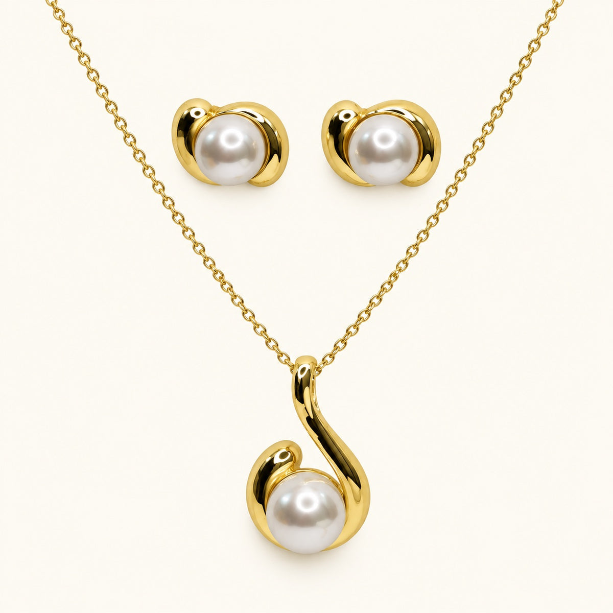 Front view of gold-tone swirl pearl pendant necklace with matching stud earrings