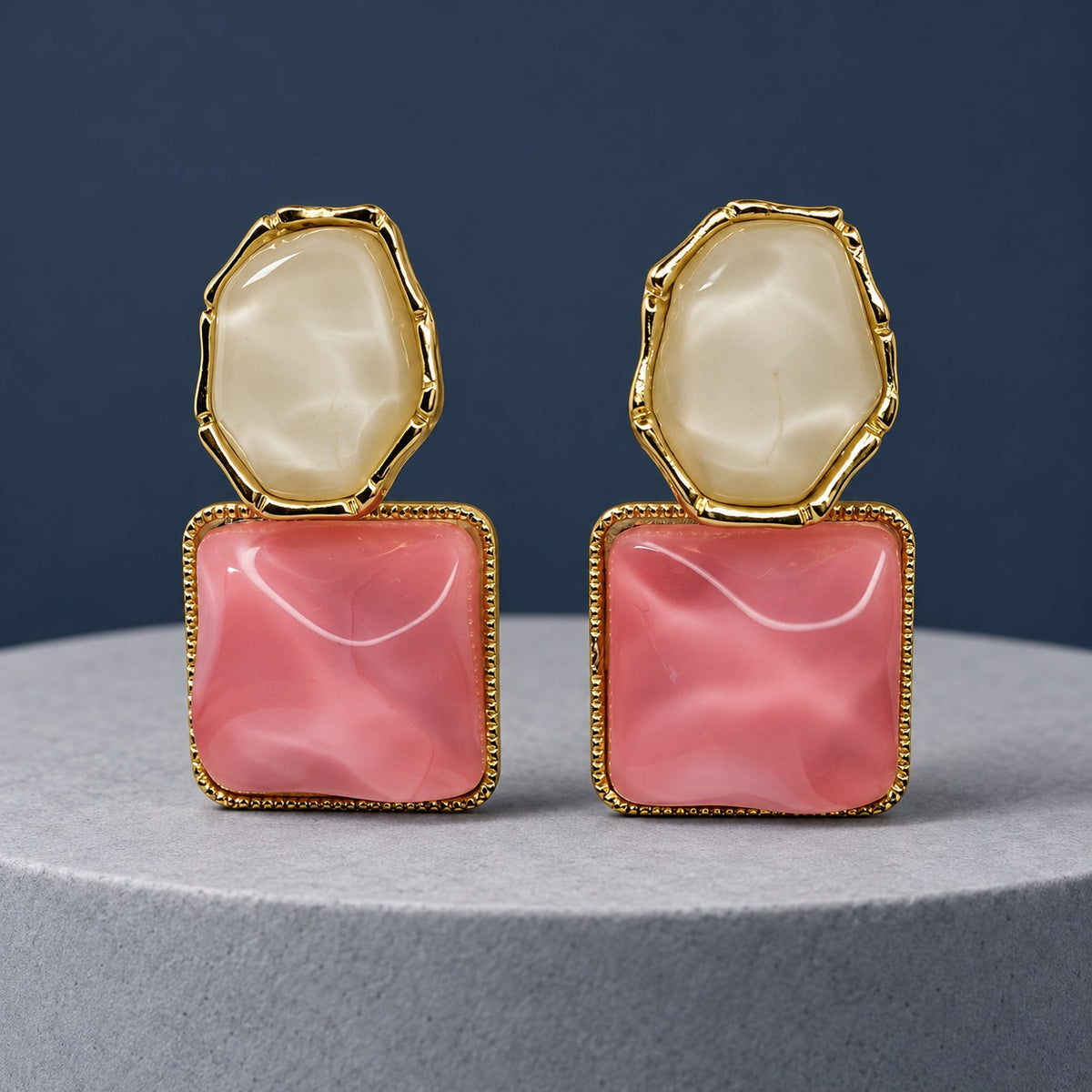 Rose Marble Square Drops gold-tone earrings with a milky stone top and pink marbled square on a grey pedestal