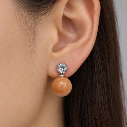 Model wearing Tangerine Lustre Orb Drops silver-tone earrings