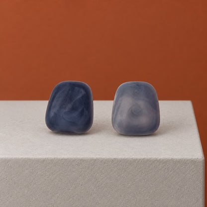 Twilight Blue Cabochon Studs dusky blue marbled cushion stud earrings on a stone block
