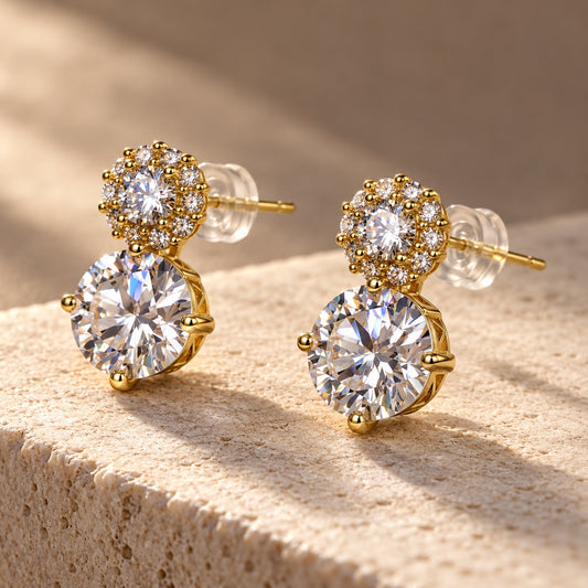 Twin Solitaire CZ Studs gold-tone earrings with a large round stone and halo top on a sandstone block