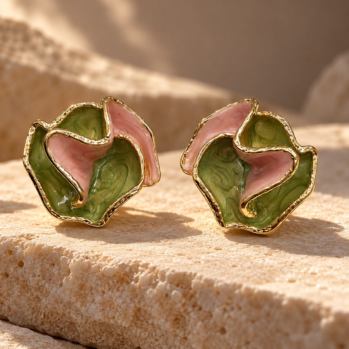Verdant Rose Enamel Studs gold-tone earrings with ruffled green and pink enamel petals on a sandstone block